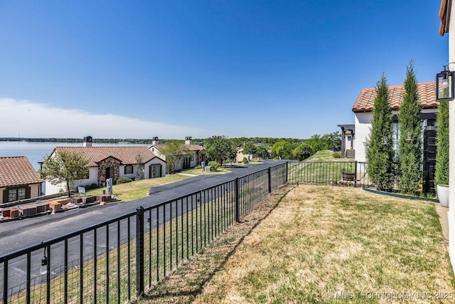 view of yard with a water view and fence