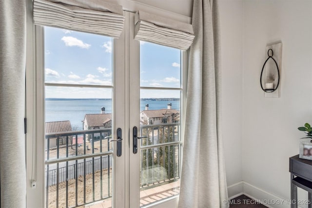 entryway with a healthy amount of sunlight, a water view, and baseboards