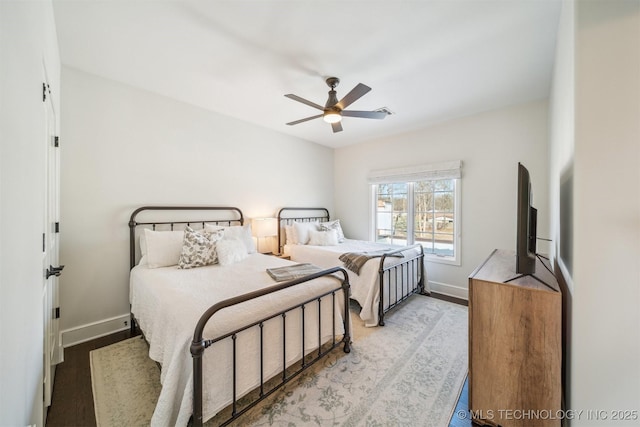 bedroom featuring a ceiling fan, baseboards, and wood finished floors