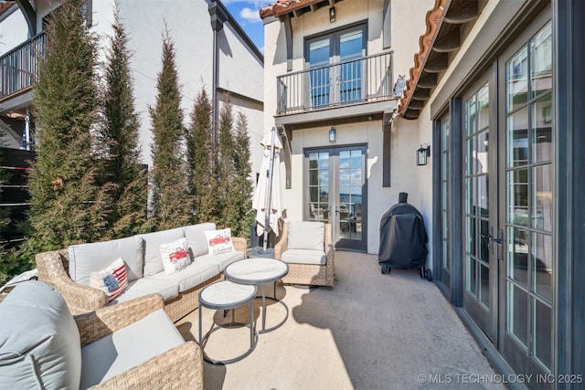 view of patio / terrace featuring a balcony, a grill, an outdoor living space, and french doors