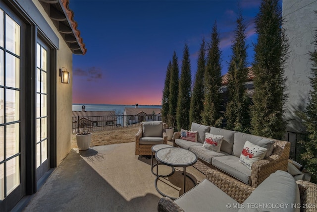 patio terrace at dusk featuring fence and an outdoor hangout area