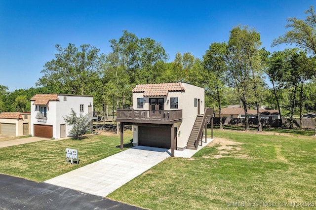 view of front of house featuring a garage, stucco siding, stairway, a tiled roof, and a front yard