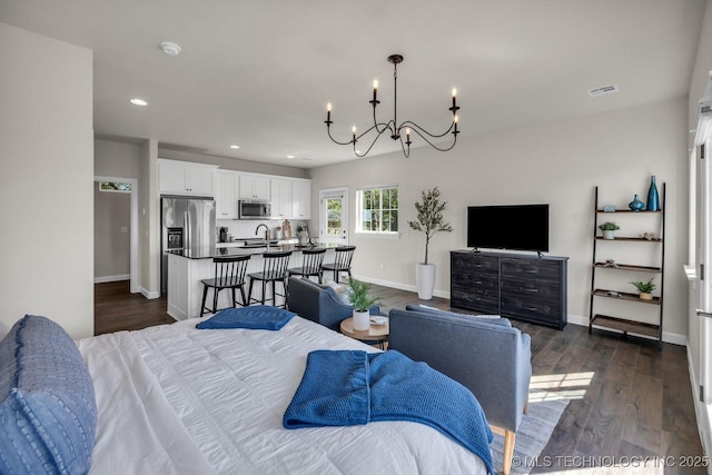 bedroom with dark wood-style flooring, stainless steel refrigerator with ice dispenser, recessed lighting, visible vents, and baseboards