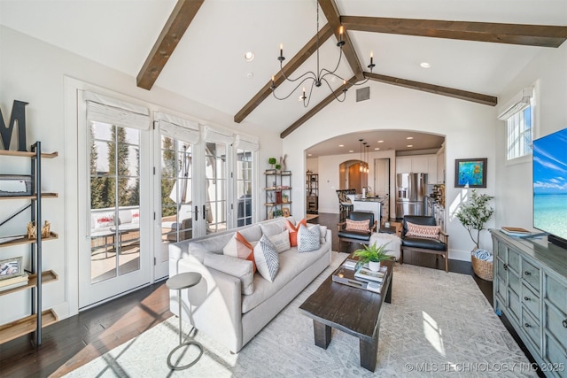 living area featuring visible vents, arched walkways, beam ceiling, and french doors