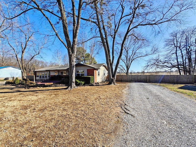 view of front of house featuring brick siding and fence