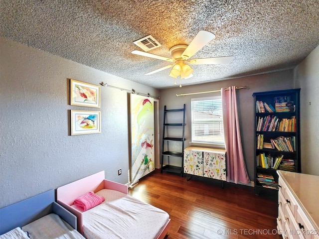 bedroom featuring dark wood-style floors, a textured wall, a textured ceiling, and visible vents