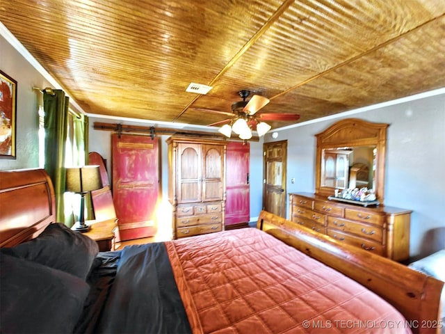 bedroom featuring ornamental molding, a barn door, and wooden ceiling