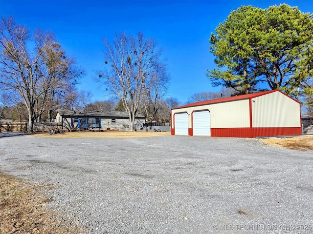 detached garage with gravel driveway