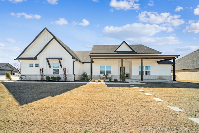 modern farmhouse style home featuring board and batten siding, a shingled roof, and a front lawn