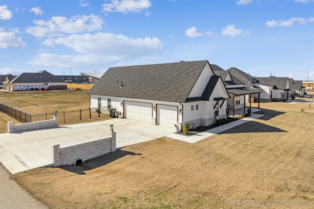 modern inspired farmhouse with a front yard, fence, driveway, an attached garage, and a shingled roof