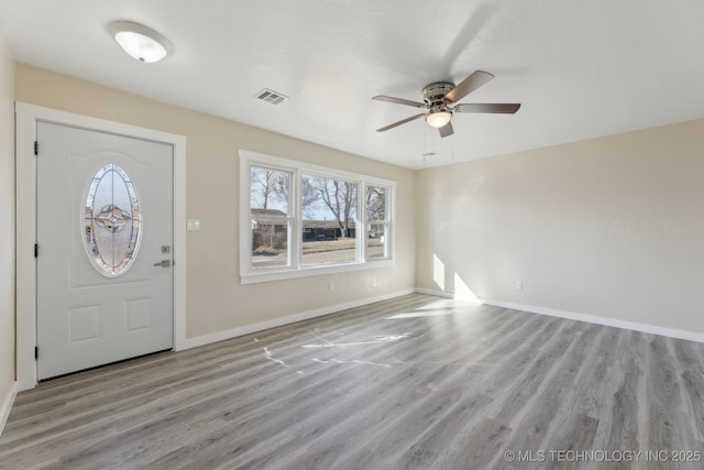 foyer entrance featuring light wood-type flooring, baseboards, visible vents, and ceiling fan