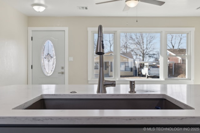 kitchen featuring light stone countertops, plenty of natural light, and visible vents