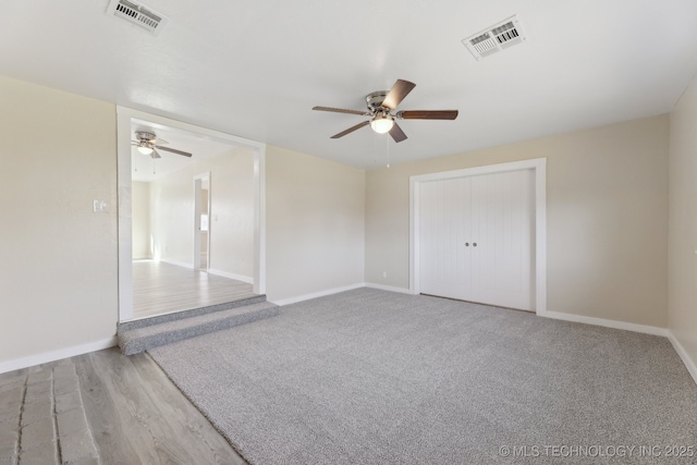 empty room with baseboards, visible vents, and a ceiling fan