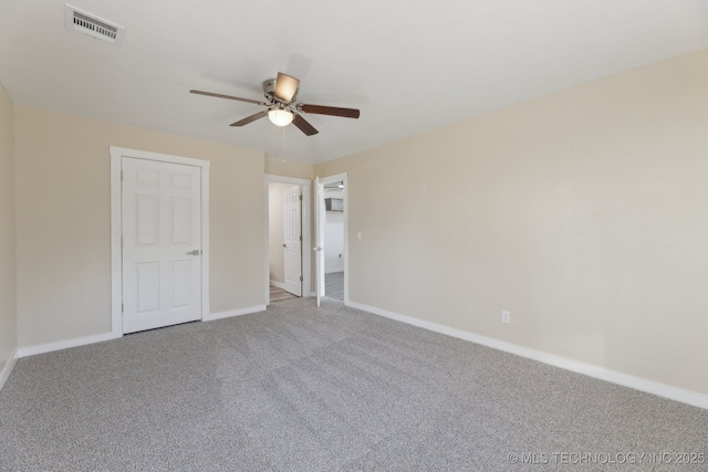 unfurnished bedroom with a ceiling fan, carpet, visible vents, and baseboards