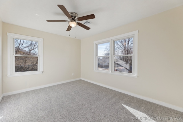 empty room featuring a ceiling fan, baseboards, visible vents, and carpet flooring