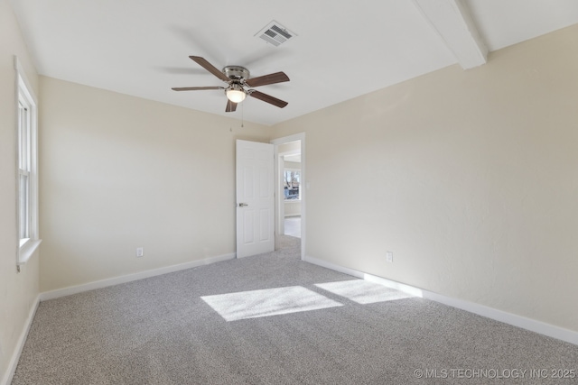 unfurnished bedroom with carpet, visible vents, a ceiling fan, beamed ceiling, and baseboards