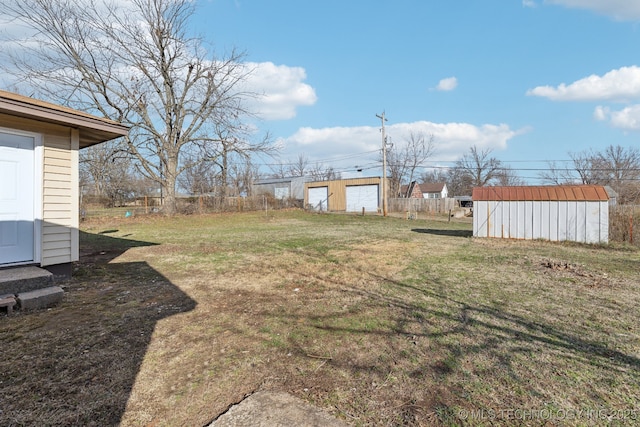 view of yard featuring an outbuilding, a shed, and fence