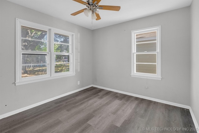 unfurnished room featuring dark wood-type flooring, a ceiling fan, and baseboards