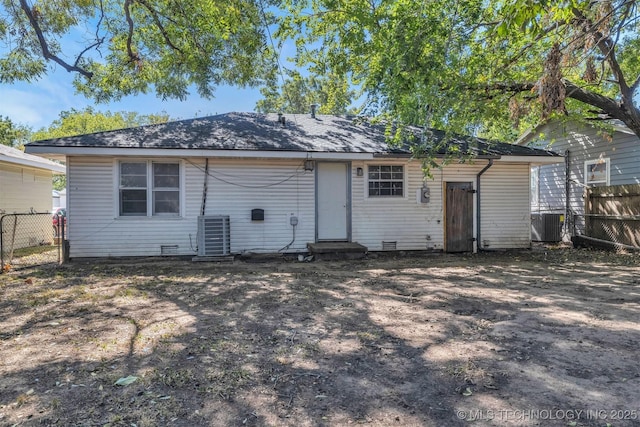 rear view of house with cooling unit, crawl space, and fence