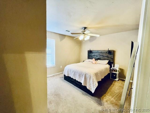 carpeted bedroom featuring visible vents and ceiling fan