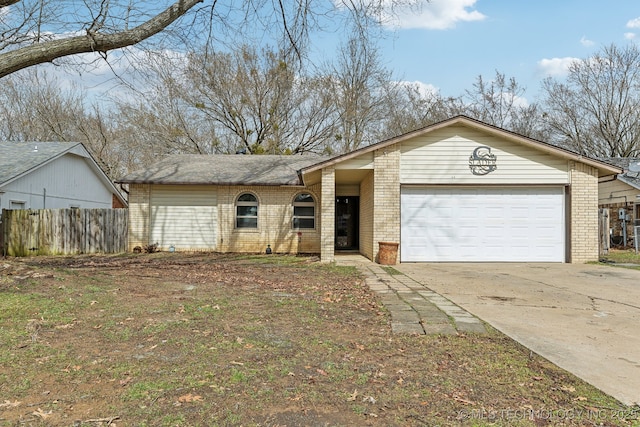 mid-century inspired home featuring concrete driveway, brick siding, fence, and an attached garage