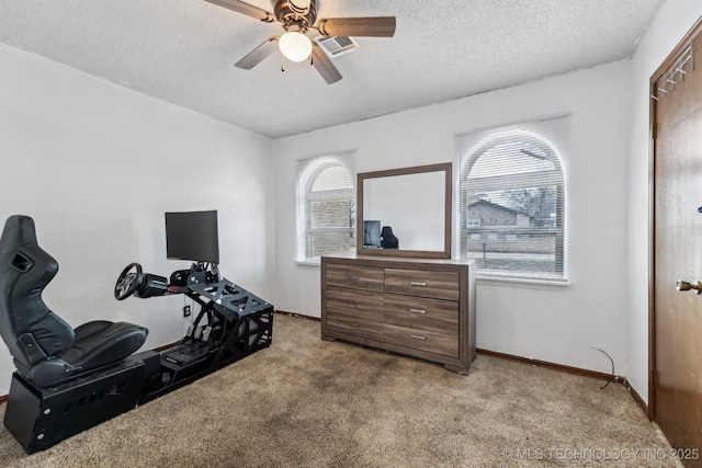 interior space featuring light carpet, baseboards, visible vents, ceiling fan, and a textured ceiling