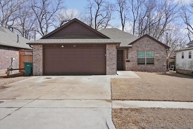 ranch-style house with concrete driveway, brick siding, and a shingled roof