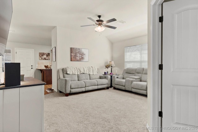 carpeted living area with ceiling fan, visible vents, and vaulted ceiling