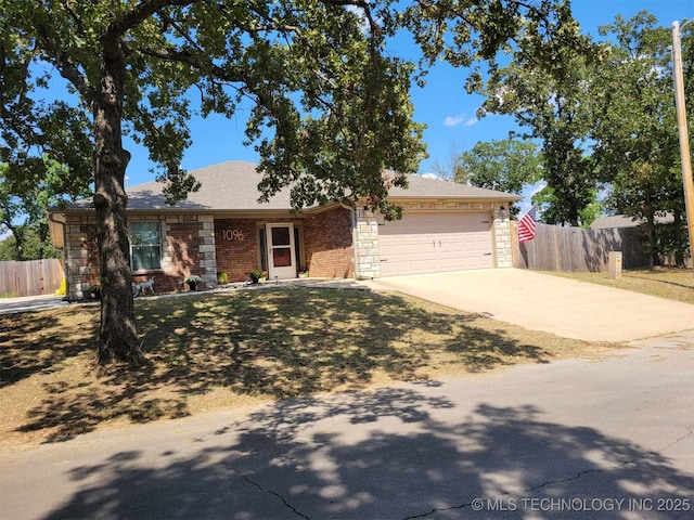 single story home featuring driveway, brick siding, an attached garage, and fence