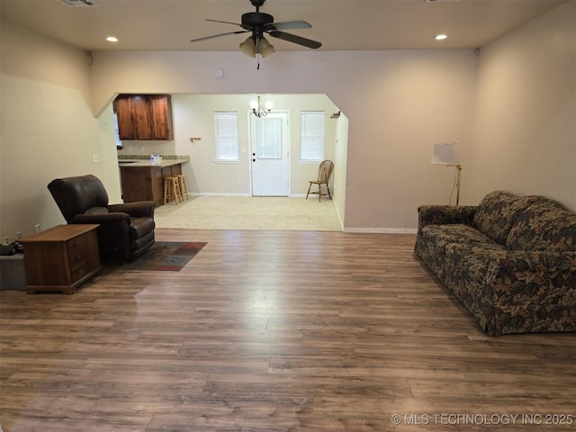 living room featuring ceiling fan, baseboards, wood finished floors, and recessed lighting