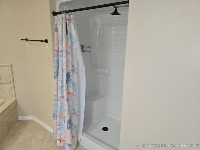 full bath with a stall shower and baseboards