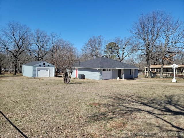 exterior space featuring a garage, an outbuilding, and central AC unit