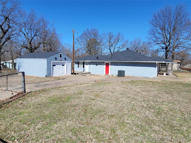 back of property with driveway, central AC unit, a yard, fence, and an outdoor structure