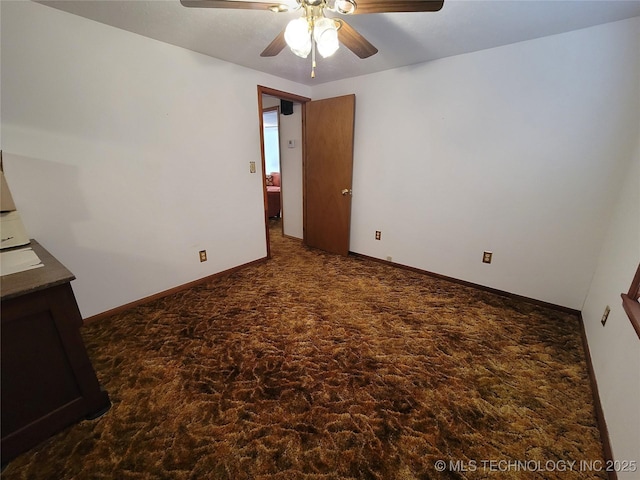 spare room with ceiling fan and baseboards
