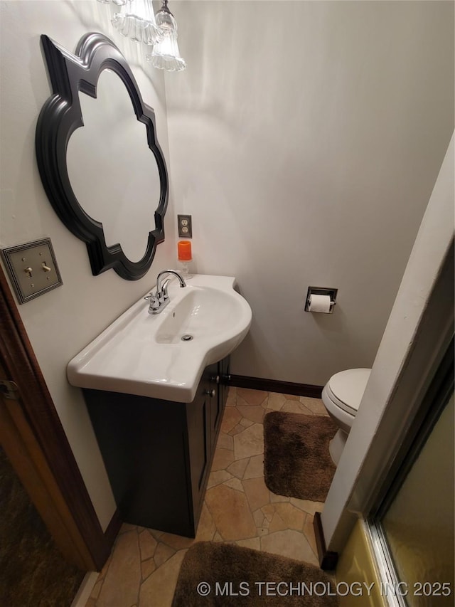 bathroom featuring toilet, tile patterned floors, baseboards, and vanity