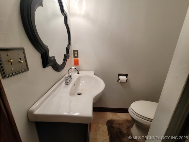bathroom featuring toilet, vanity, baseboards, and tile patterned floors