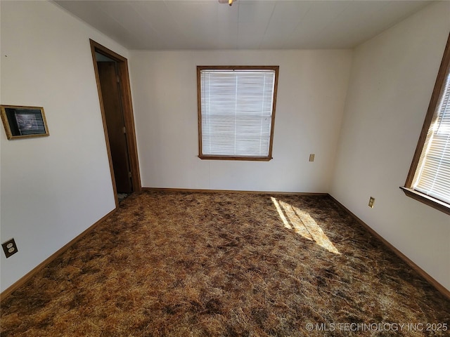 carpeted spare room featuring baseboards