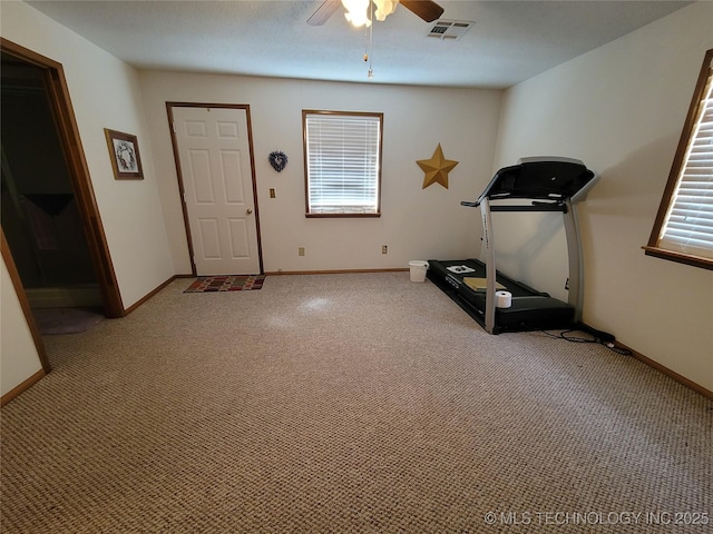 exercise room with light carpet, visible vents, baseboards, and ceiling fan