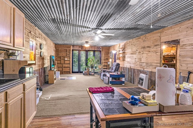 interior space with a ceiling fan and wooden walls