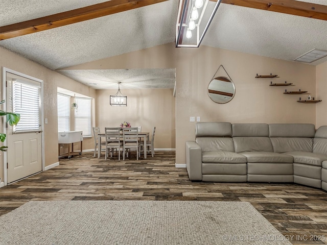 living room featuring lofted ceiling with beams, a textured ceiling, visible vents, and wood finished floors