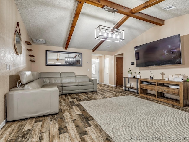 living area featuring visible vents, vaulted ceiling with beams, a textured ceiling, and wood finished floors