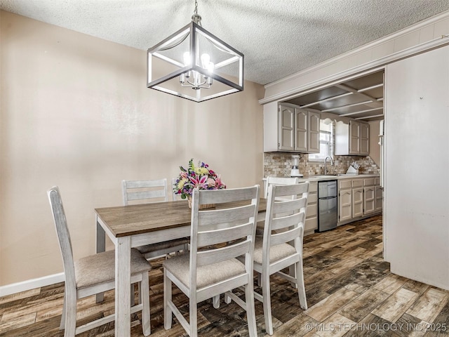 dining space featuring an inviting chandelier, a textured ceiling, baseboards, and dark wood-style flooring