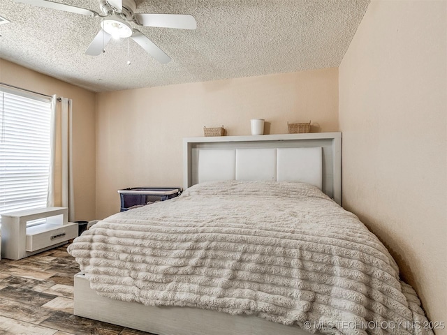 bedroom with a textured ceiling, a ceiling fan, and wood finished floors