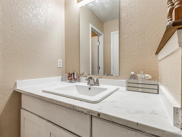 bathroom featuring vanity and a textured wall