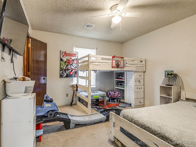 bedroom featuring a textured ceiling, ceiling fan, carpet flooring, and visible vents