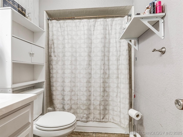 bathroom with shower / bathtub combination with curtain, vanity, and toilet