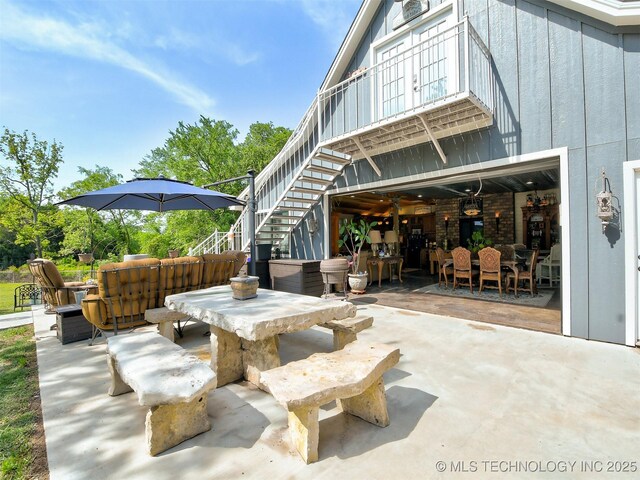 view of patio with outdoor dining area and stairs