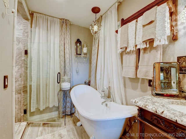 bathroom with a freestanding bath, vanity, and a shower stall