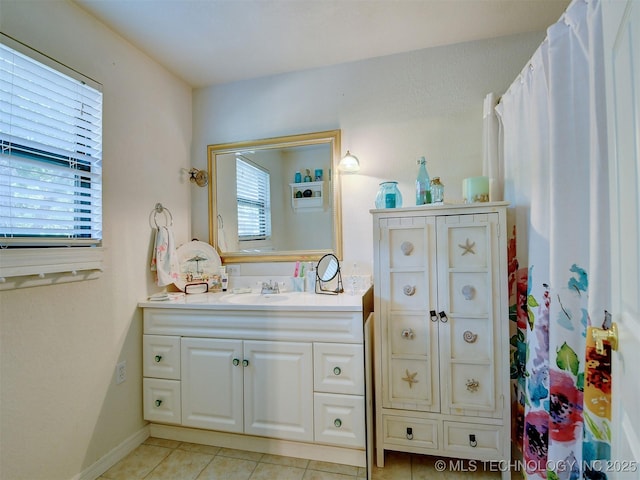 bathroom with baseboards, vanity, and tile patterned floors