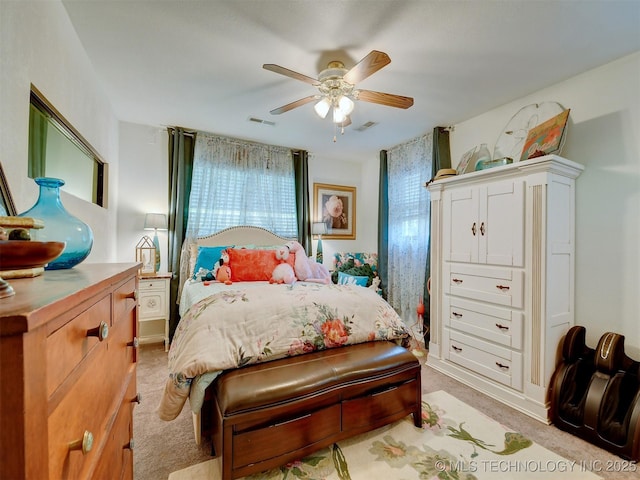 bedroom with visible vents, a ceiling fan, and light colored carpet